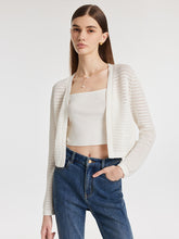 A lady wears a cropped cardigan.
